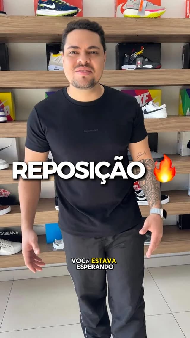 O dono da Narciso na loja, na frente da parede de tênis